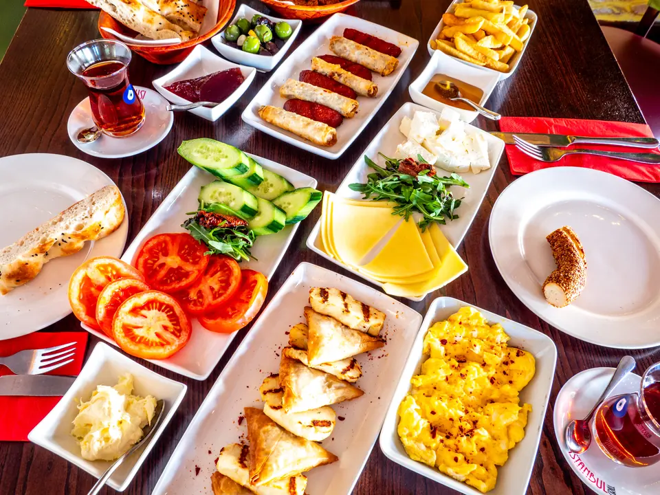 A Turkish breakfast spread for the table: börek, sucuk, eggs, cheeses, tomatoes and tea
