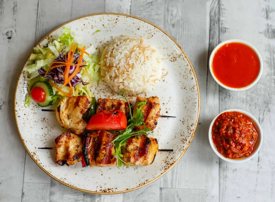 Chargrilled chicken skewers with rice, salad and dips