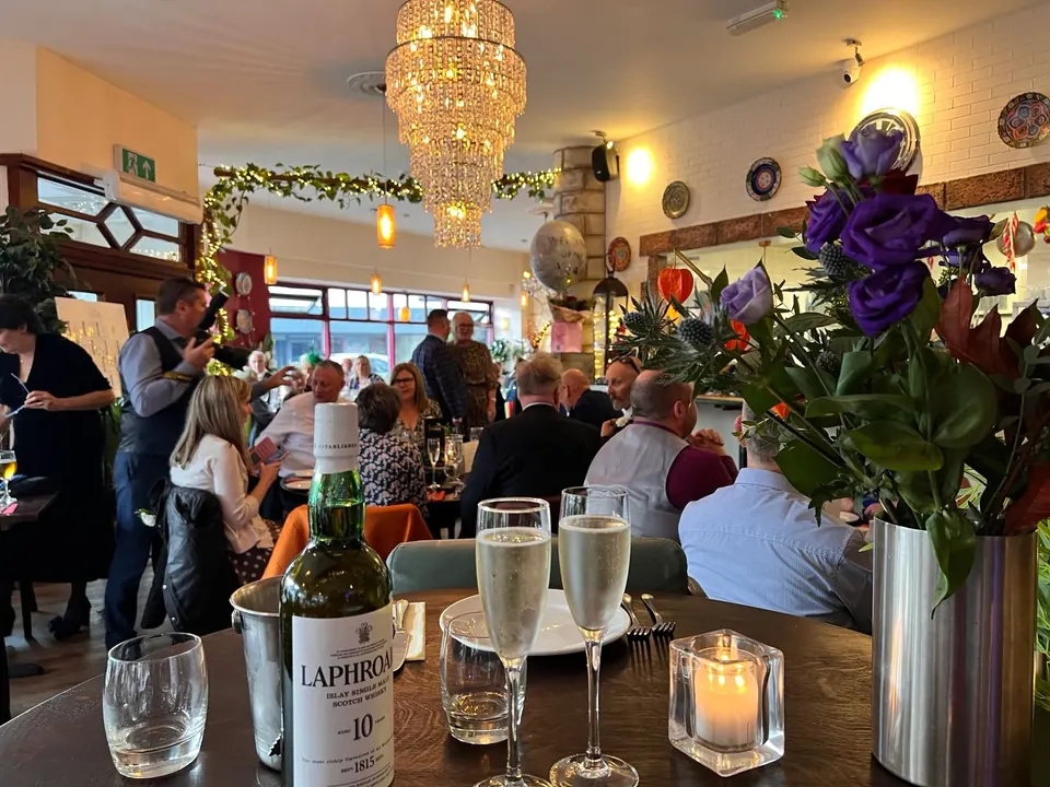 A celebration in the dining room at Istanbul Grill, under a crystal chandelier, with prosecco on the table