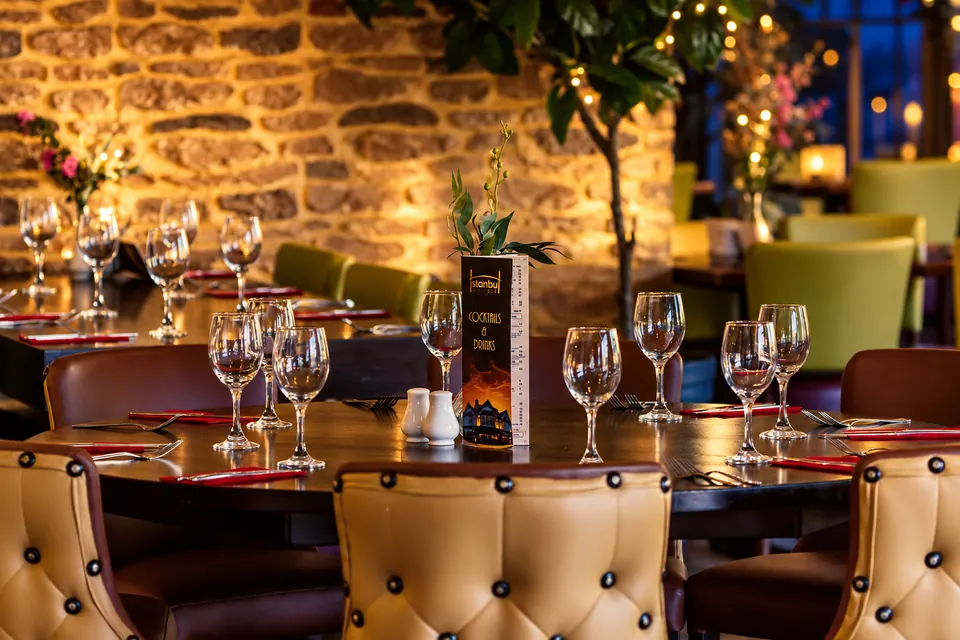 Tables laid for dinner by the windows