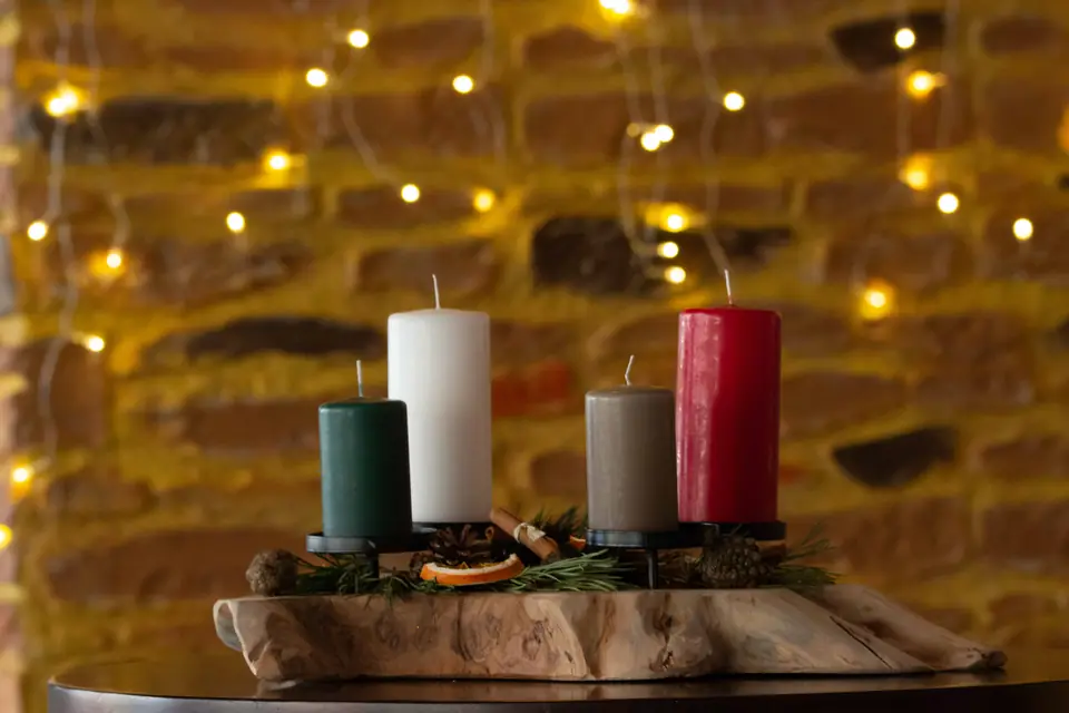 Candles among fairy lights on the sandstone wall